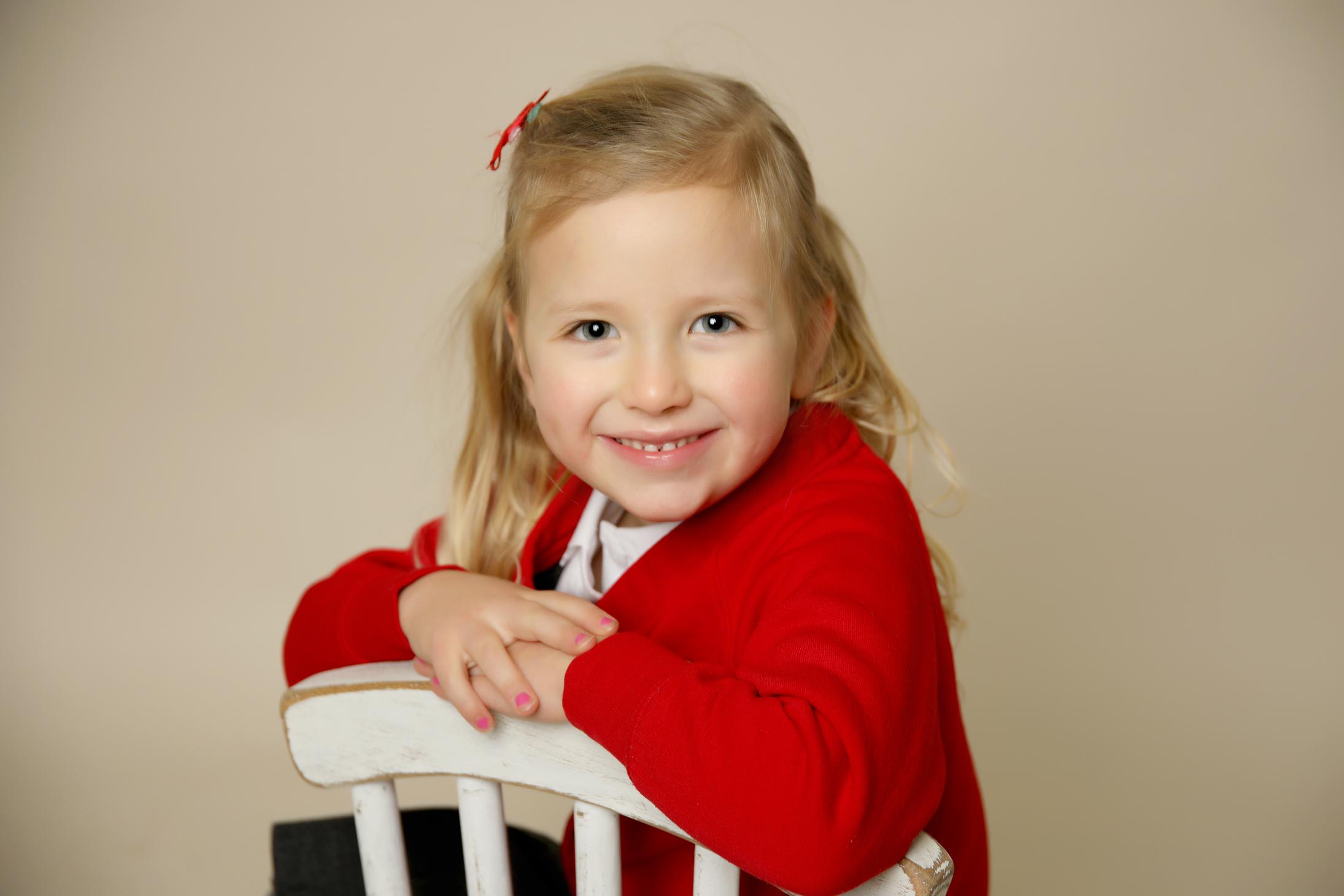 young girl with blonde hair and a red school uniform by Primary School Photographer Gateshead, Newcastle and County Durham